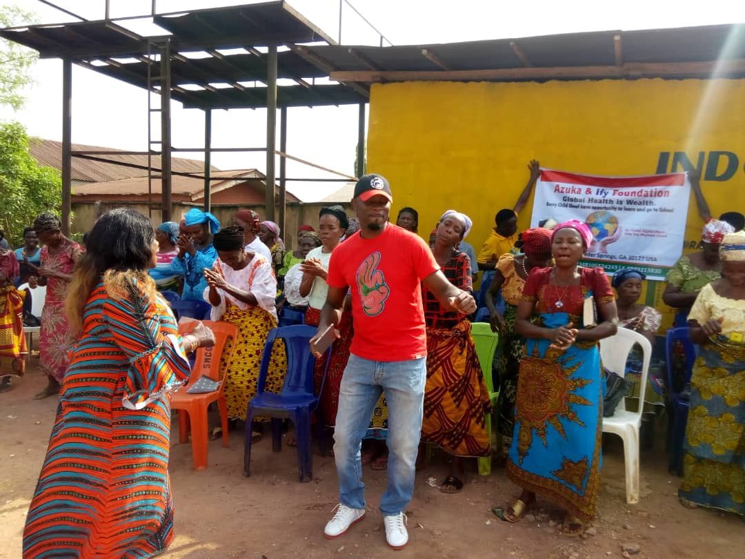 A group of people are dancing in front of a sign that says ind
