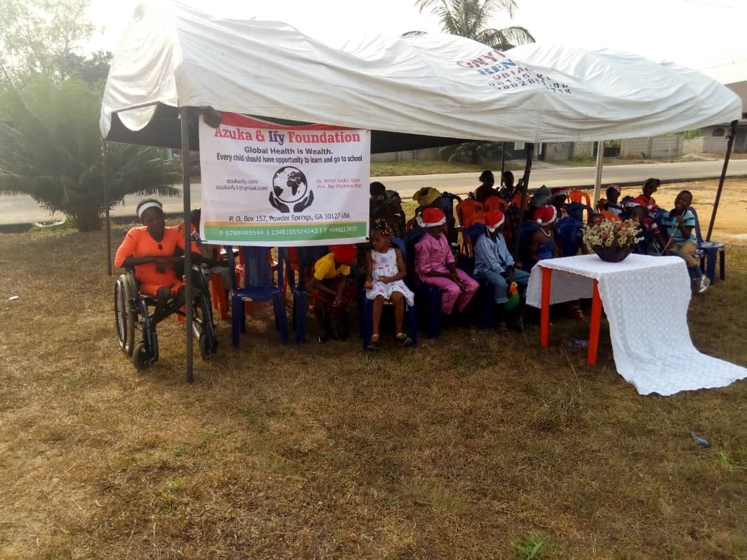 A group of people are sitting under a tent.