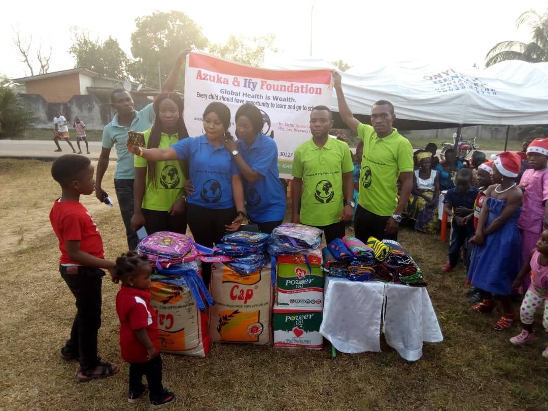 A group of people are posing for a picture in front of a table full of donations.