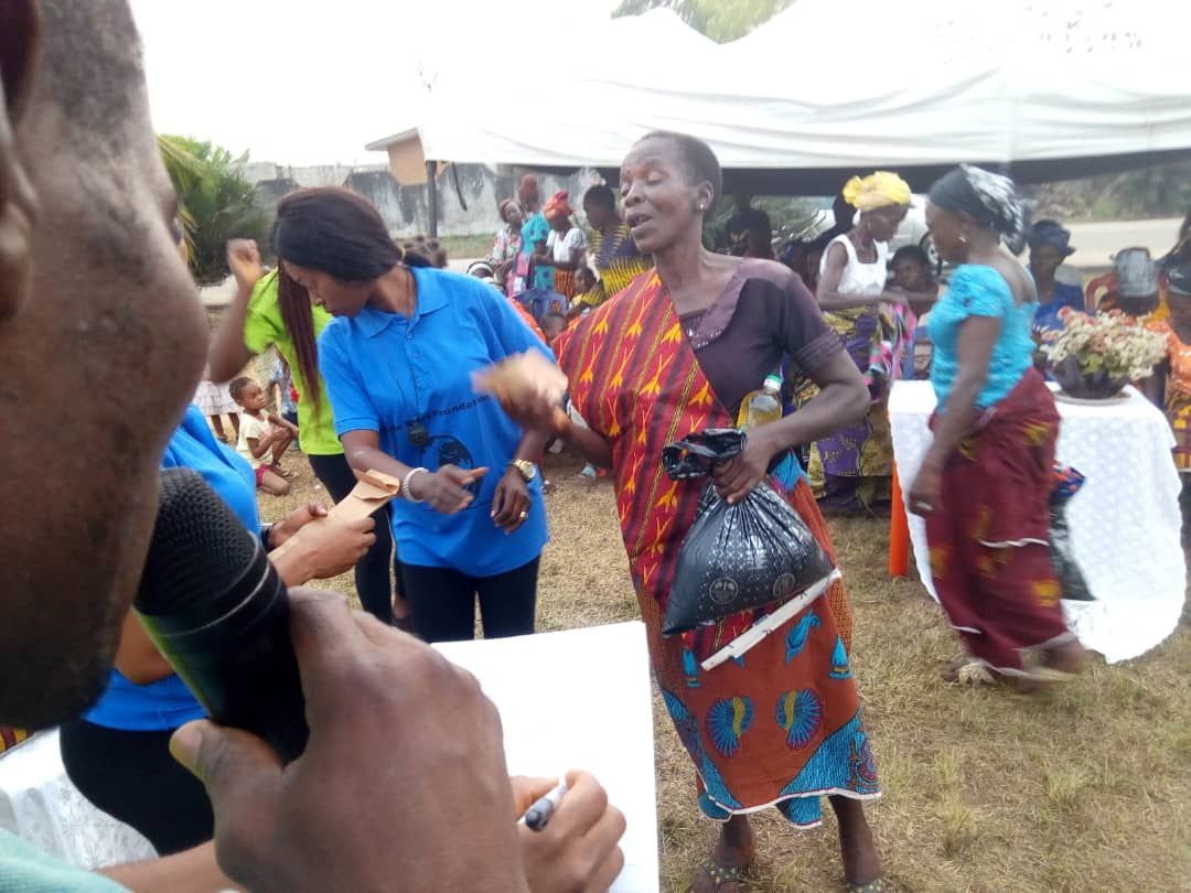 A man is holding a microphone in front of a group of people