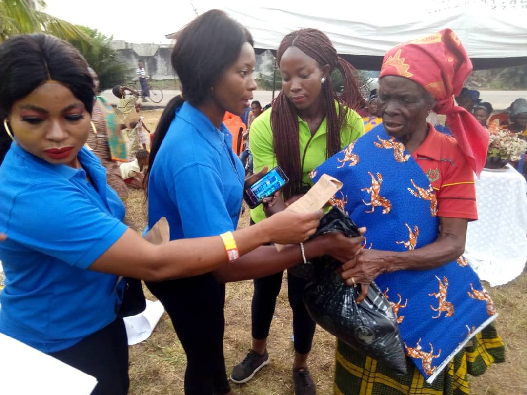 A group of women are standing around a woman in a blue shirt.