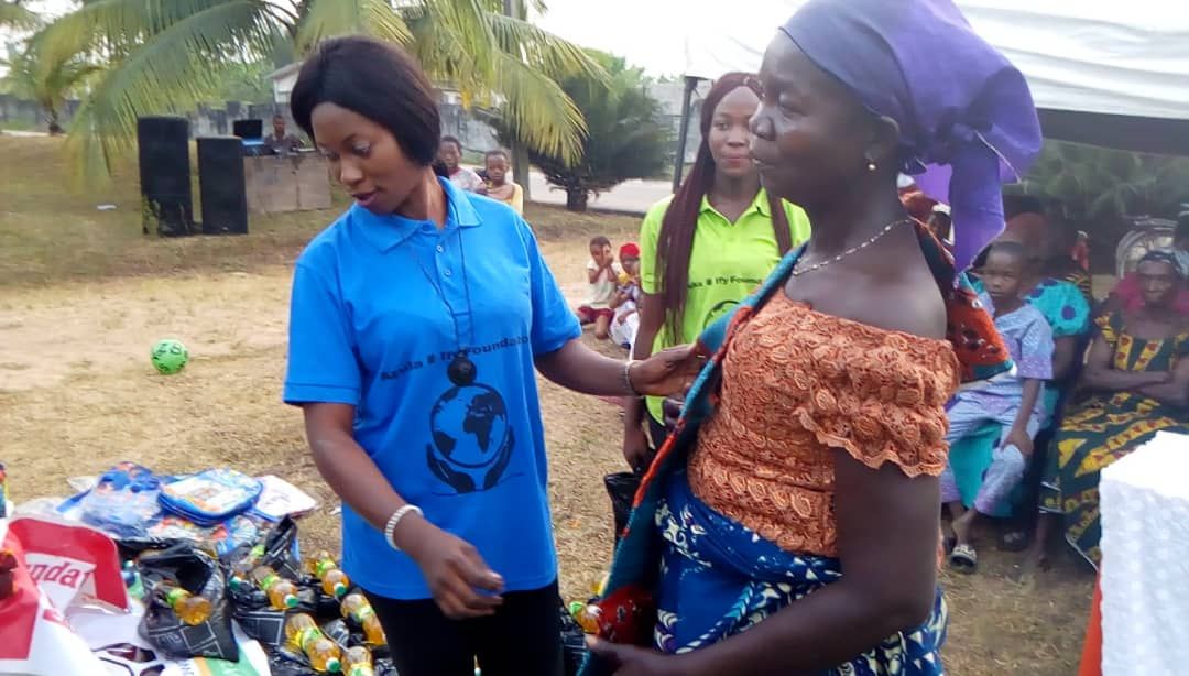 A woman in a blue shirt is standing next to a woman in an orange dress.