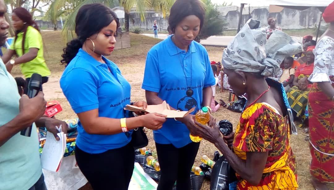 A group of people are standing around a woman holding a piece of paper.