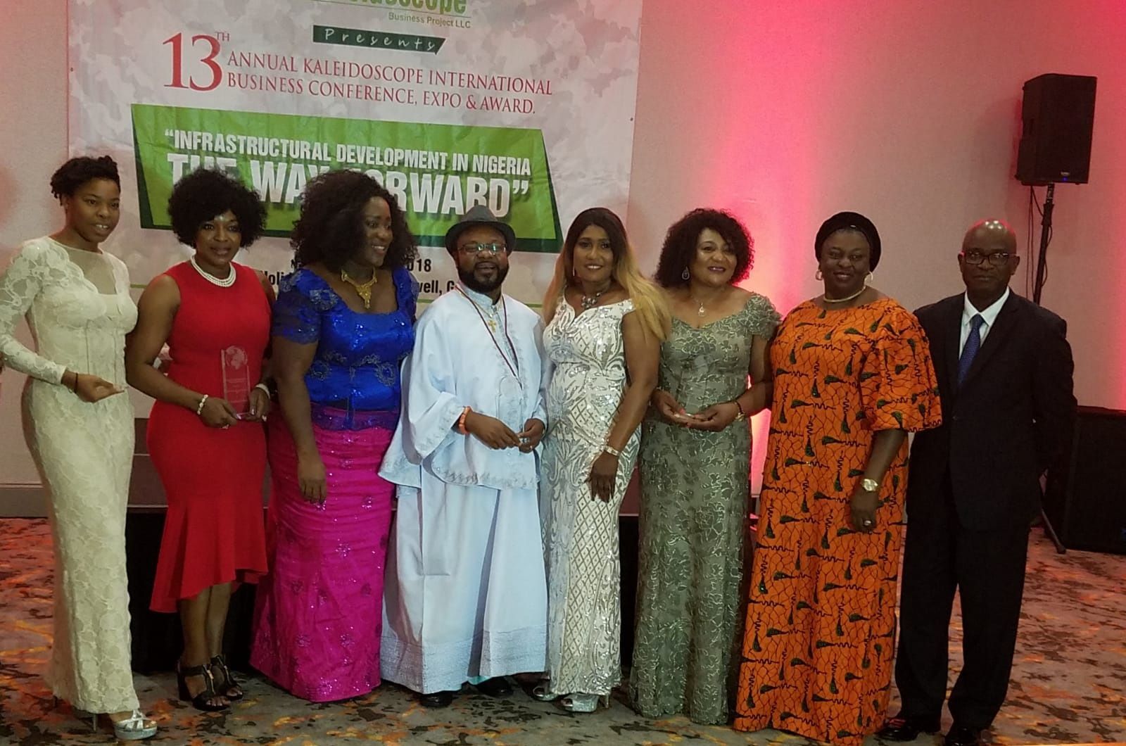 A group of people are posing for a picture in front of a sign that says 13
