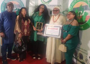 A group of people are standing next to each other on a red carpet.