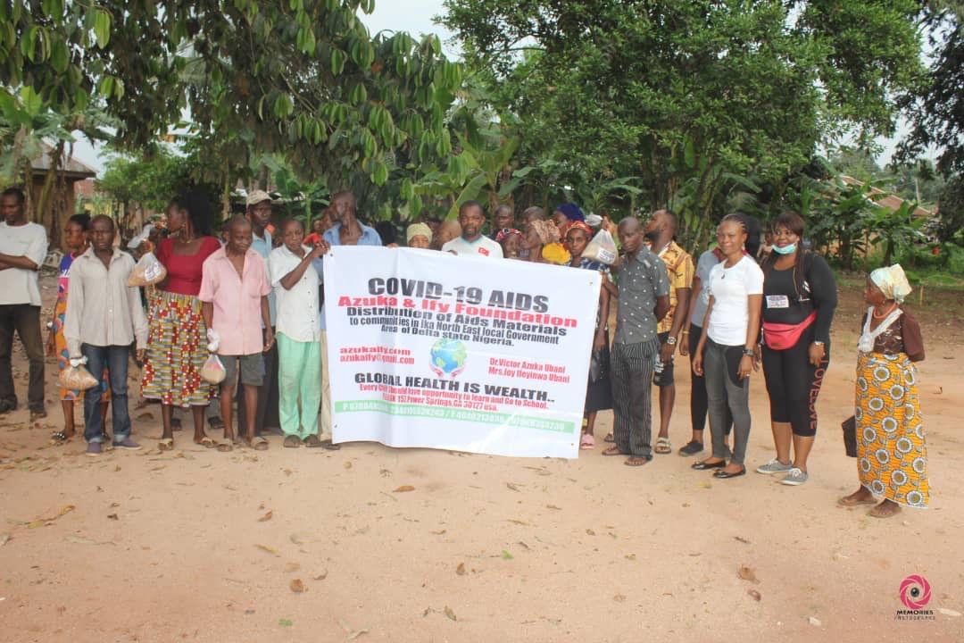 A group of people are standing in a field holding a sign.