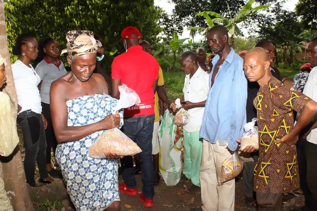 A group of people are standing around a woman holding a bag of food.