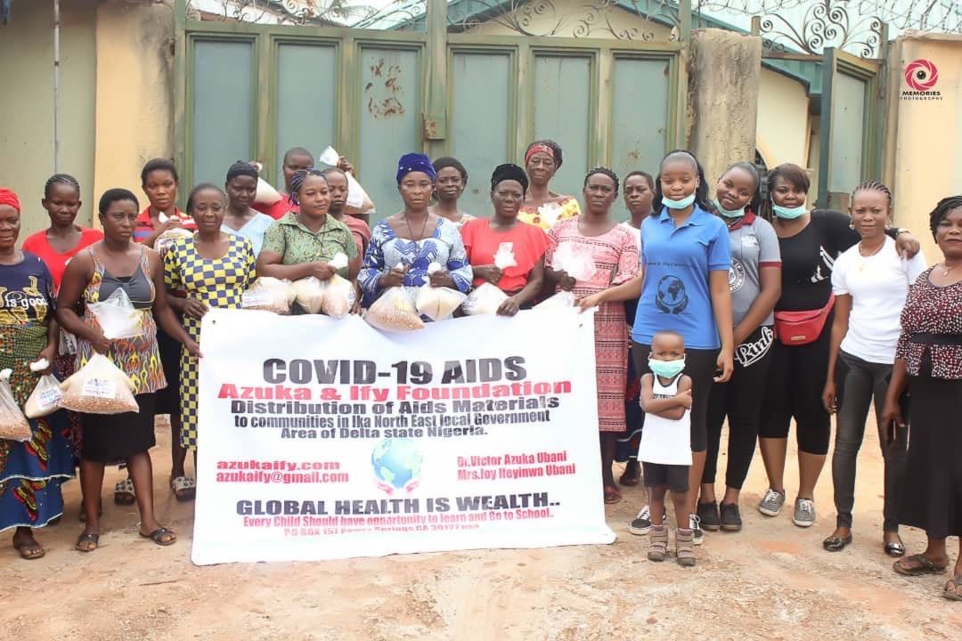A group of people are standing in front of a sign that says covid-19 aids.
