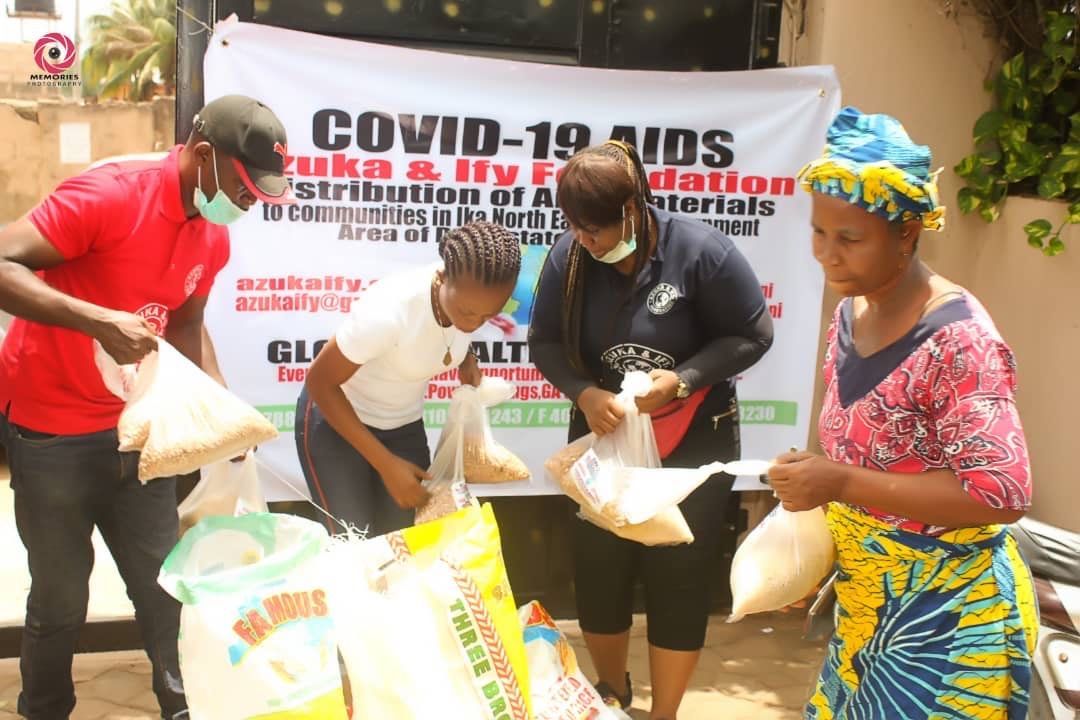 A group of people are standing in front of a sign that says covid-19 aids