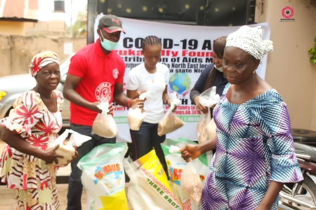 A group of people standing in front of a sign that says covid-19