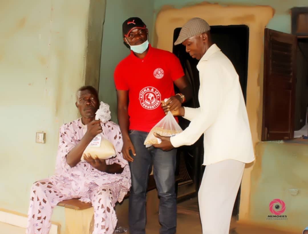 A man in a red shirt is giving a bag of food to another man