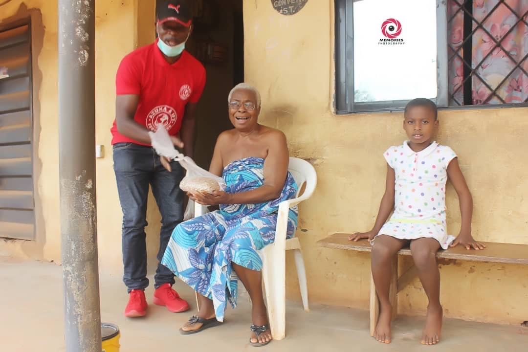 A man is standing next to a woman sitting in a chair and a little girl sitting on a bench.