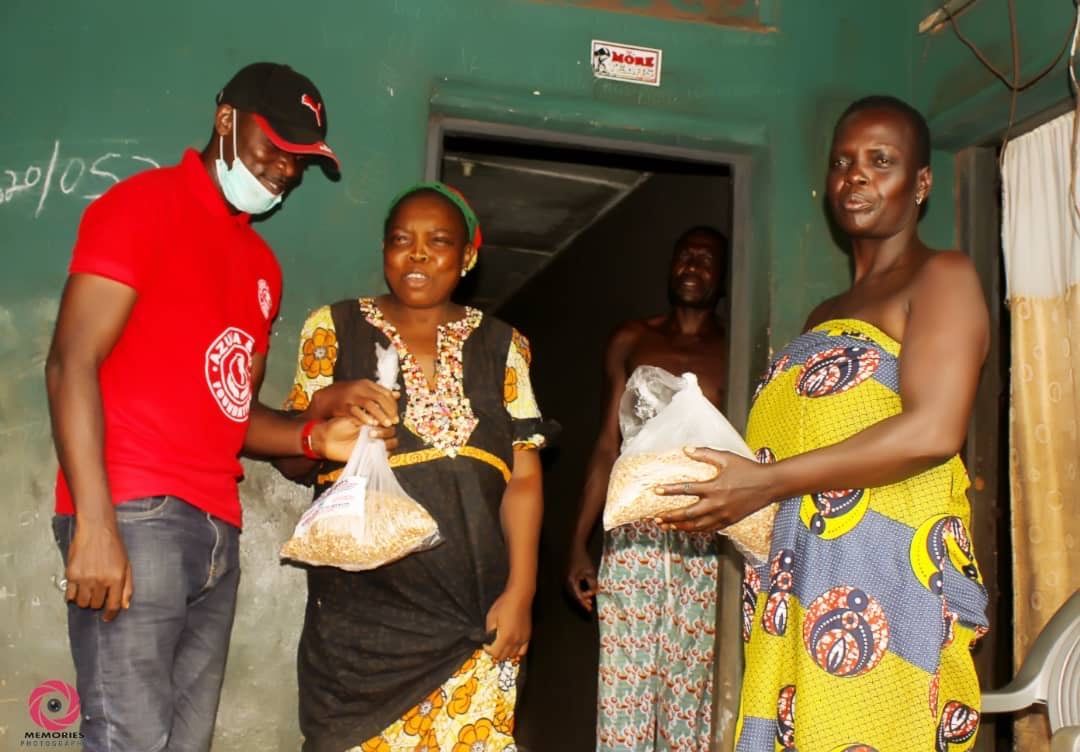 A man in a red shirt is giving food to two women