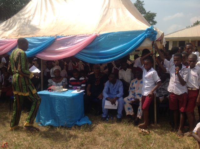 A group of people are gathered under a tent.
