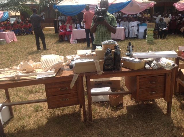 A man is taking a picture of a table with a skeleton on it