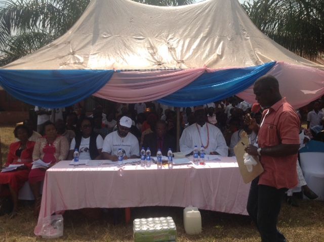 A group of people sitting at a table under a tent