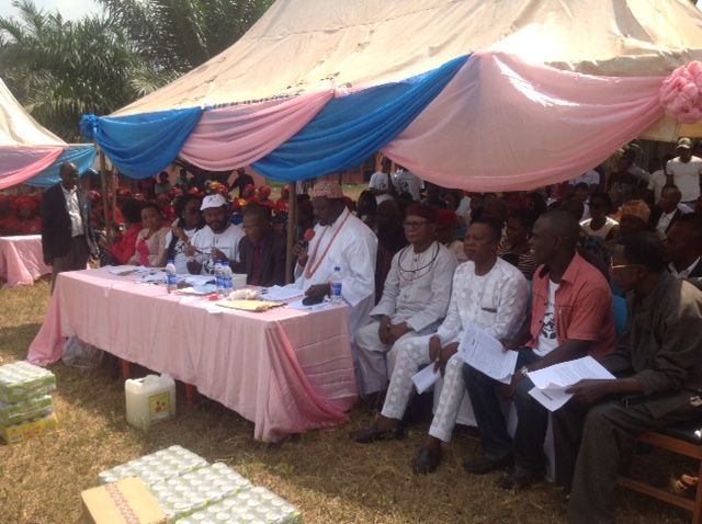 A group of people are sitting under a tent