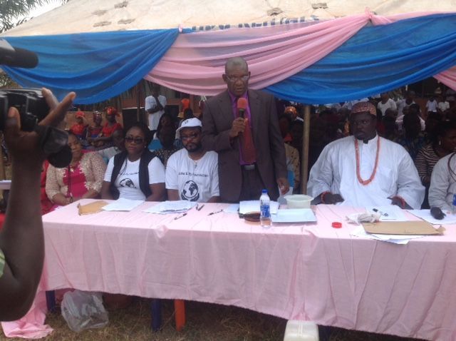 A group of people are sitting at a table under a tent.