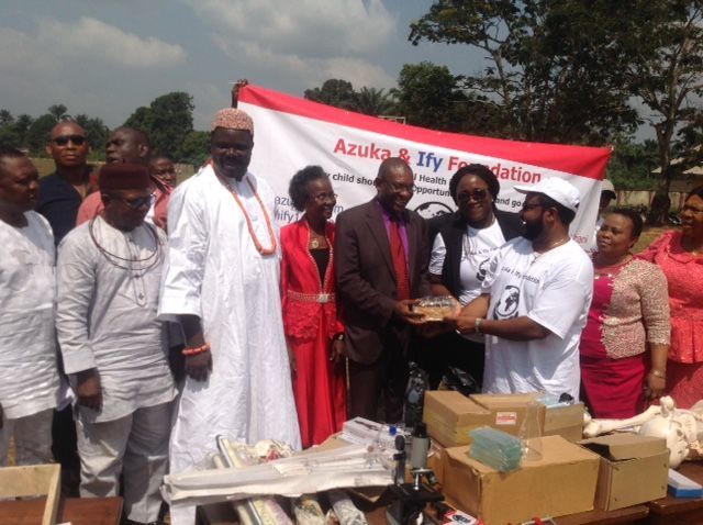 A group of people standing in front of a banner that says azuka