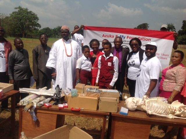 A group of people are posing for a picture in front of a sign that says azuka safety foundation