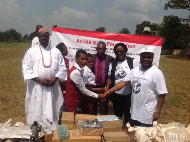 A group of people shaking hands in front of a sign that says azuka foundation