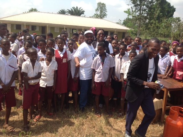 A man in a suit stands in front of a group of children