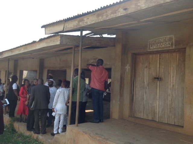 A group of people are standing outside of a building that says service chamber