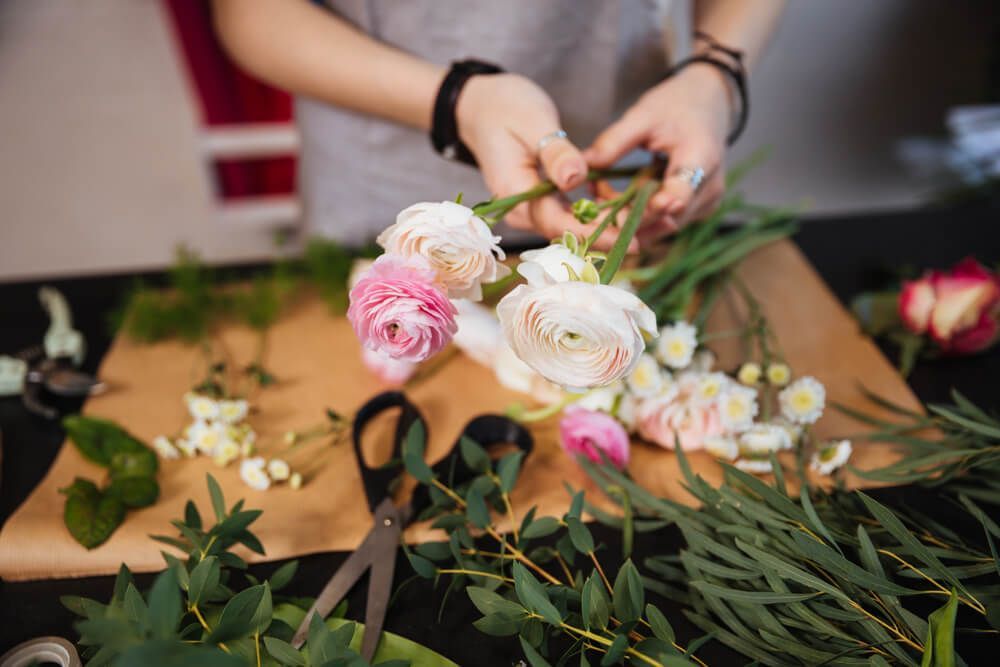 Closeup of hands of young woman florist creating bouquet — Castletown Flower Hut in Pimlico, QLD