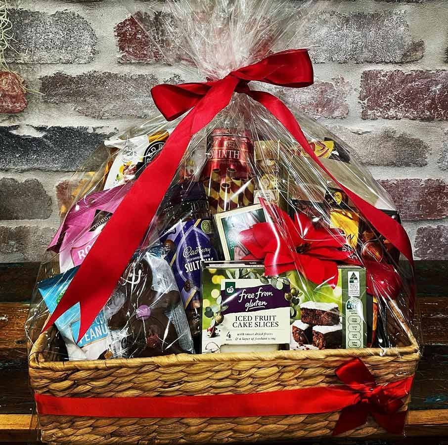 A Gift Basket Wrapped in Plastic and Tied With a Red Ribbon — Castletown Flower Hut in Pimlico, QLD