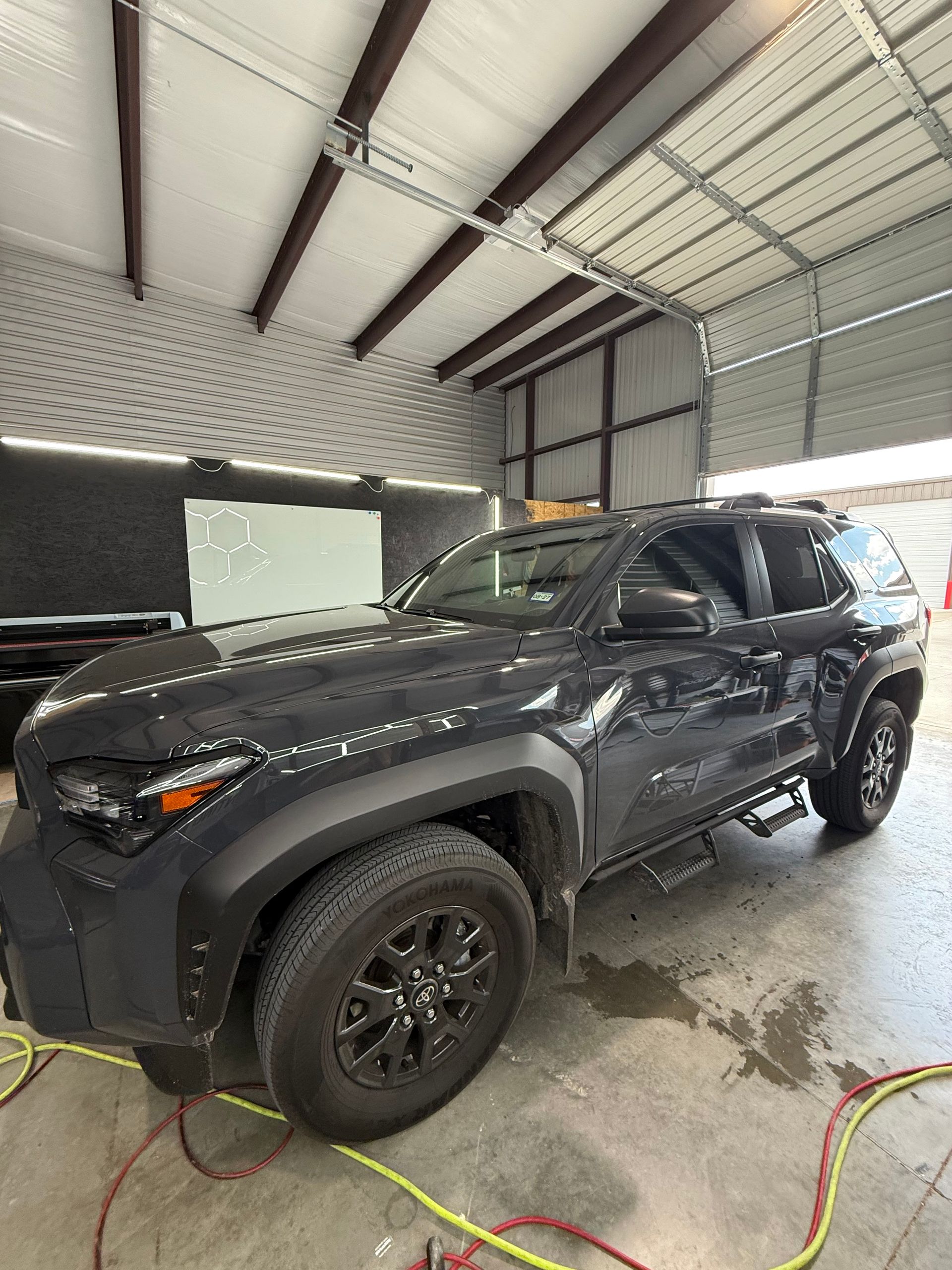 Dark gray Toyota SUV parked in a garage with black wheels and trim.
