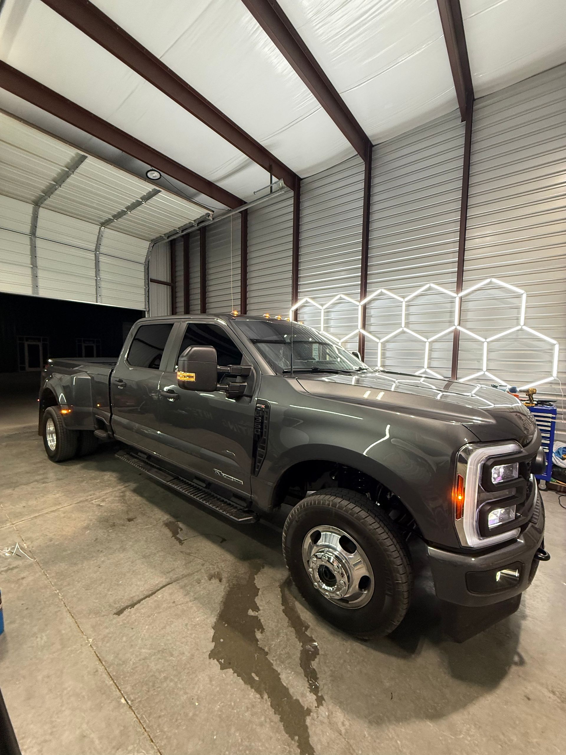 Gray Ford truck parked inside a building with a white ceiling and hexagonal wall feature.