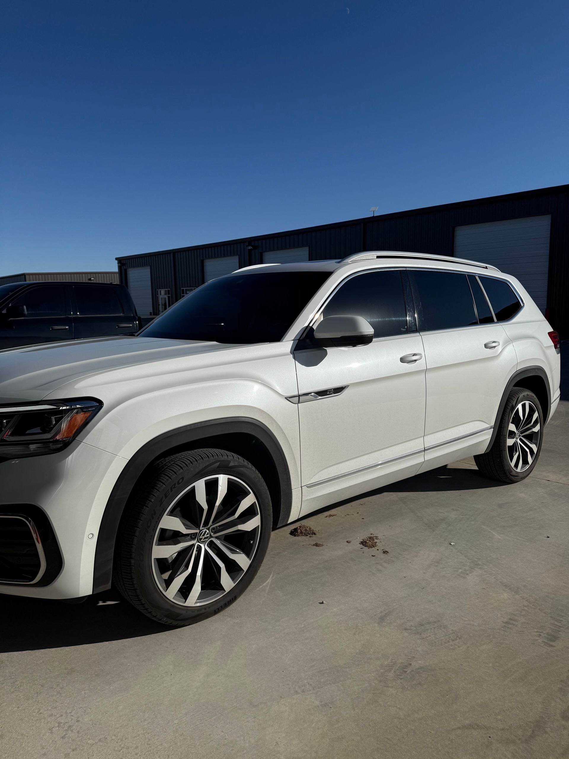 White Volkswagen Atlas SUV parked outdoors on a sunny day.