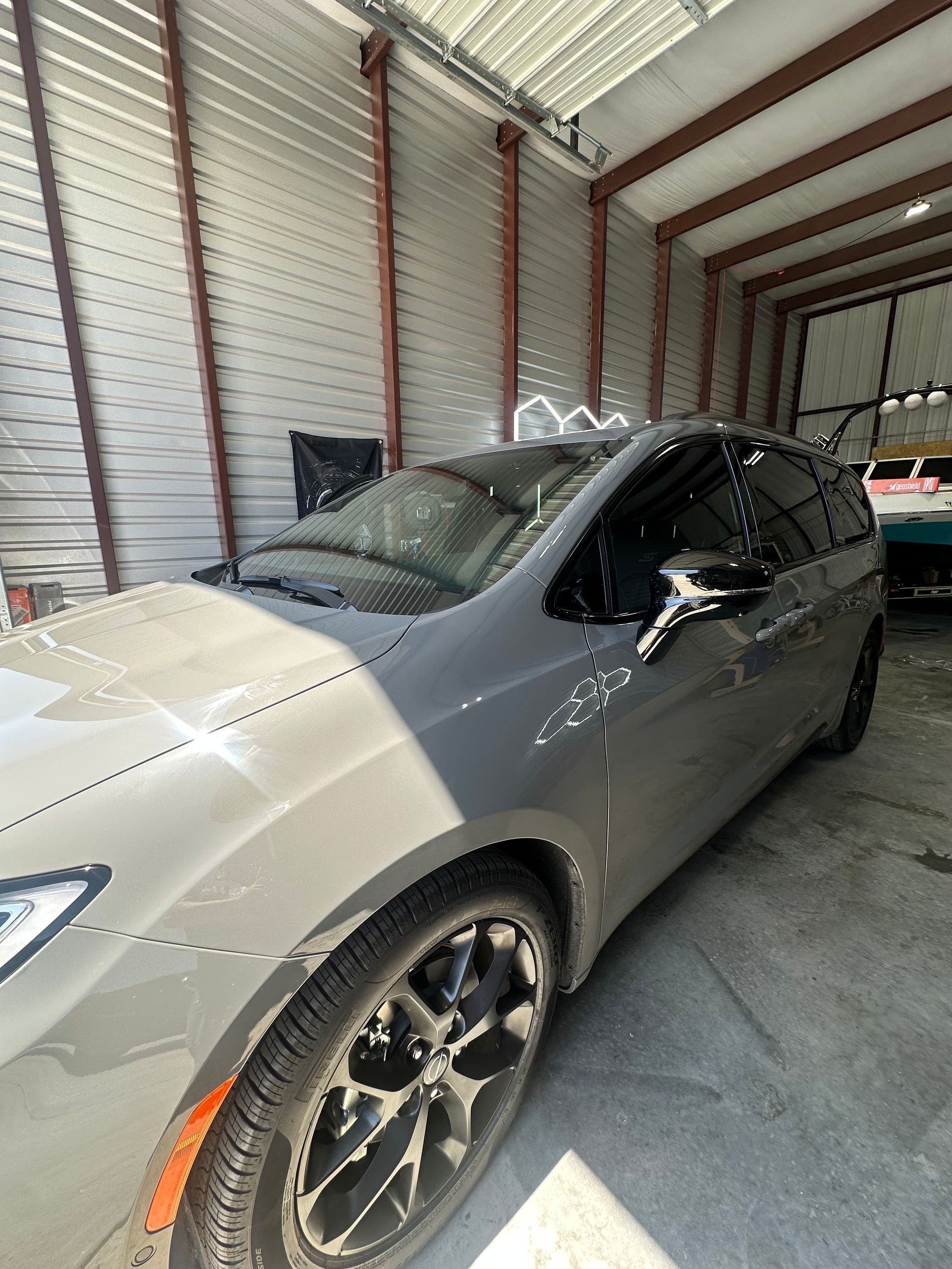 Gray minivan inside a garage with tinted windows.