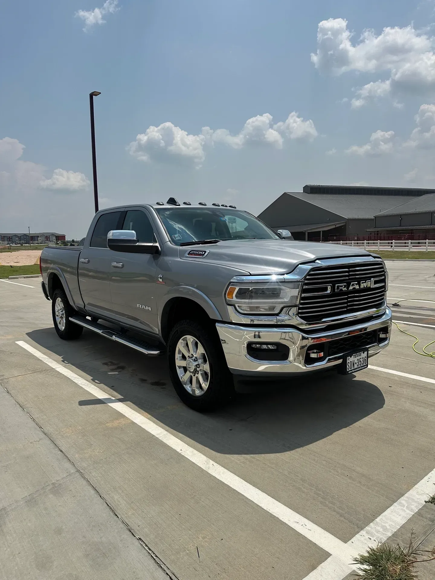 Gray Ram pickup truck parked on concrete, sunny day.