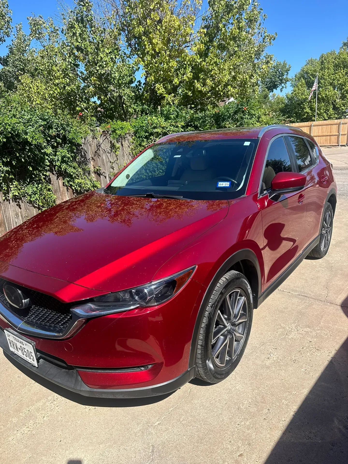 Red Mazda CX-5 SUV parked outside on a sunny day.