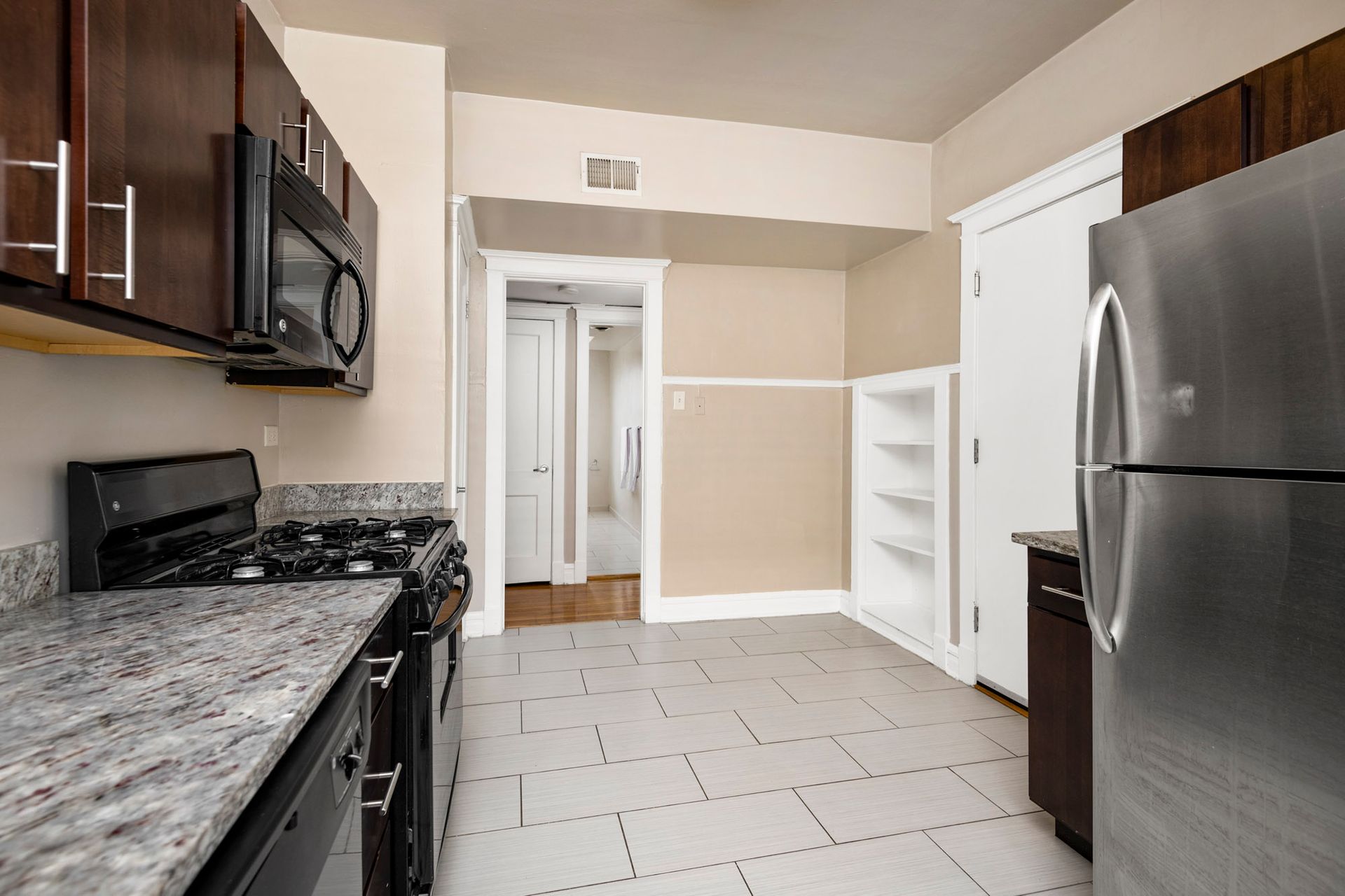 A kitchen with stainless steel appliances and granite counter tops at Reside on Irving Park.
