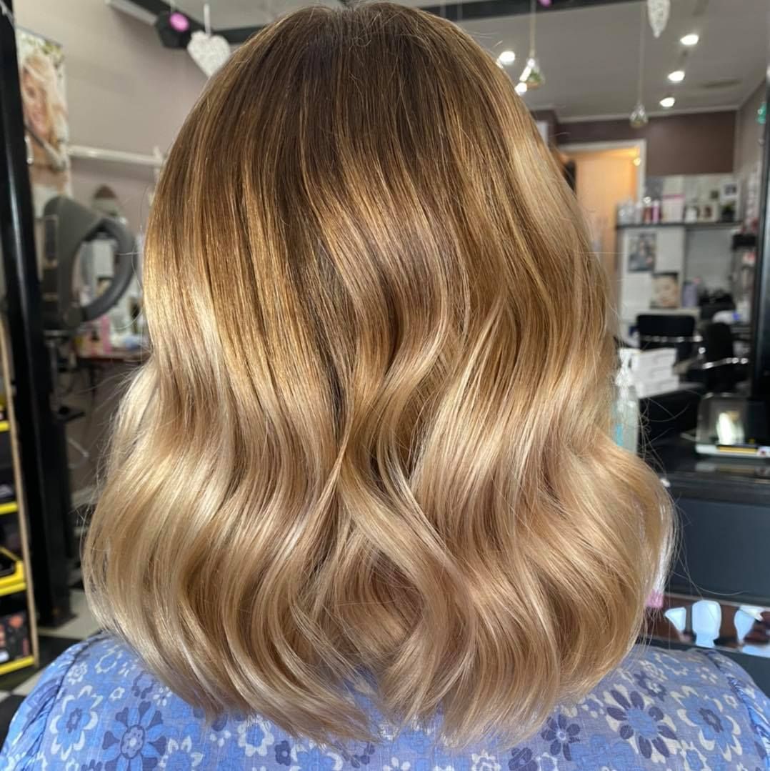 A Woman with Blonde Hair Is Sitting in A Chair in A Salon — Ammo Hair and Beauty In Maclean, NSW