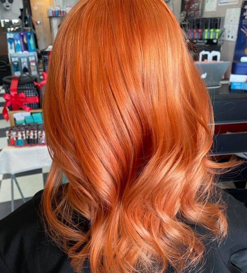 A Woman with Red Hair Is Sitting in A Chair in A Salon— Ammo Hair and Beauty In Maclean, NSW