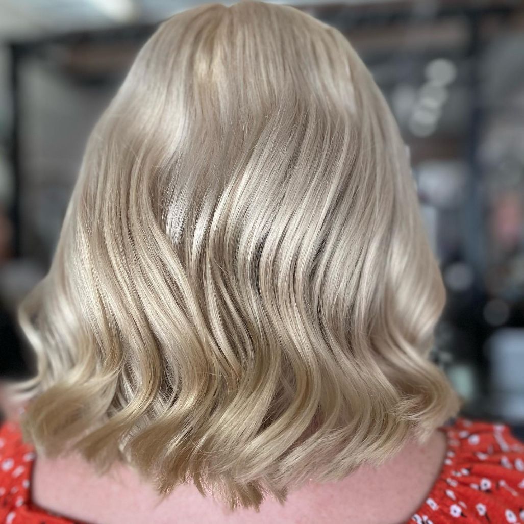 A Woman with Blonde Hair Is Wearing a Red Shirt — Ammo Hair and Beauty In Maclean, NSW