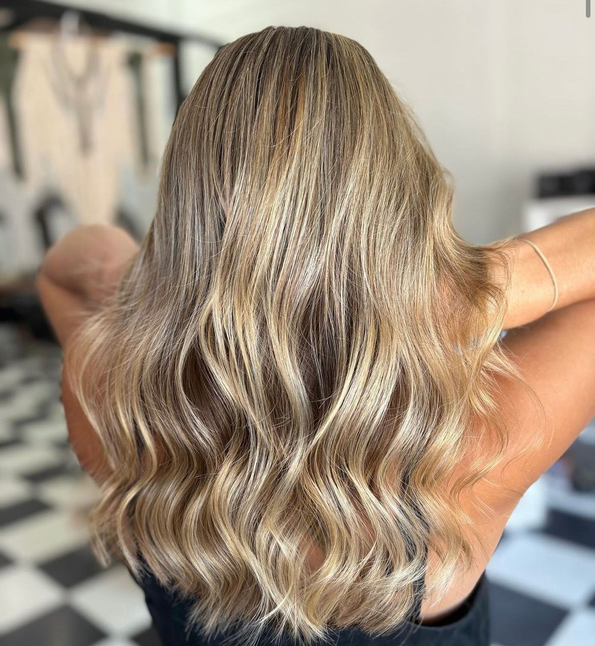 A Woman with Long Blonde hair while standing in hair salon— Ammo Hair and Beauty In Maclean, NSW