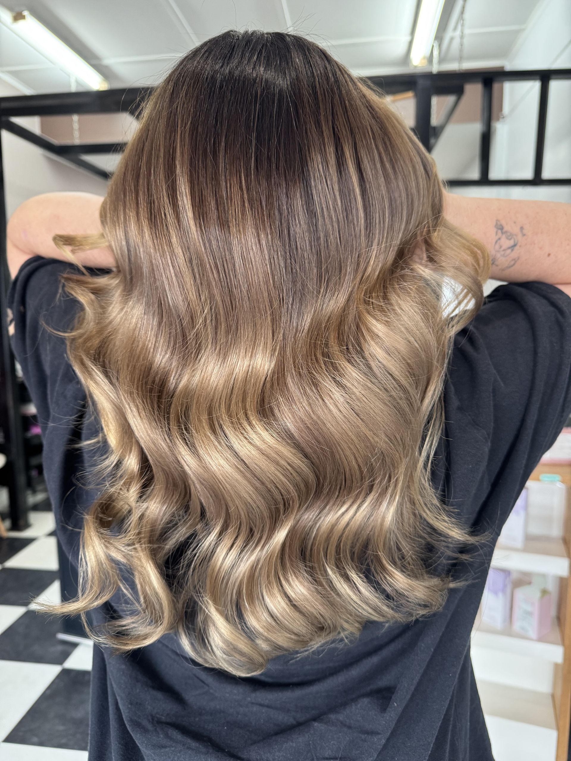 A Woman with Long Bronde Hair Is Standing with hands to head in A Salon — Ammo Hair and Beauty In Maclean, NSW