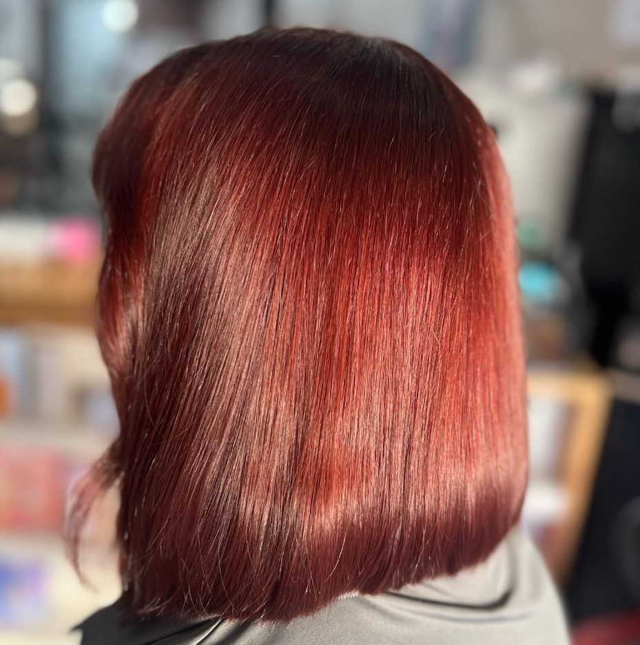 A Woman with Red Hair Is Wearing a Grey Shirt — Ammo Hair and Beauty In Maclean, NSW