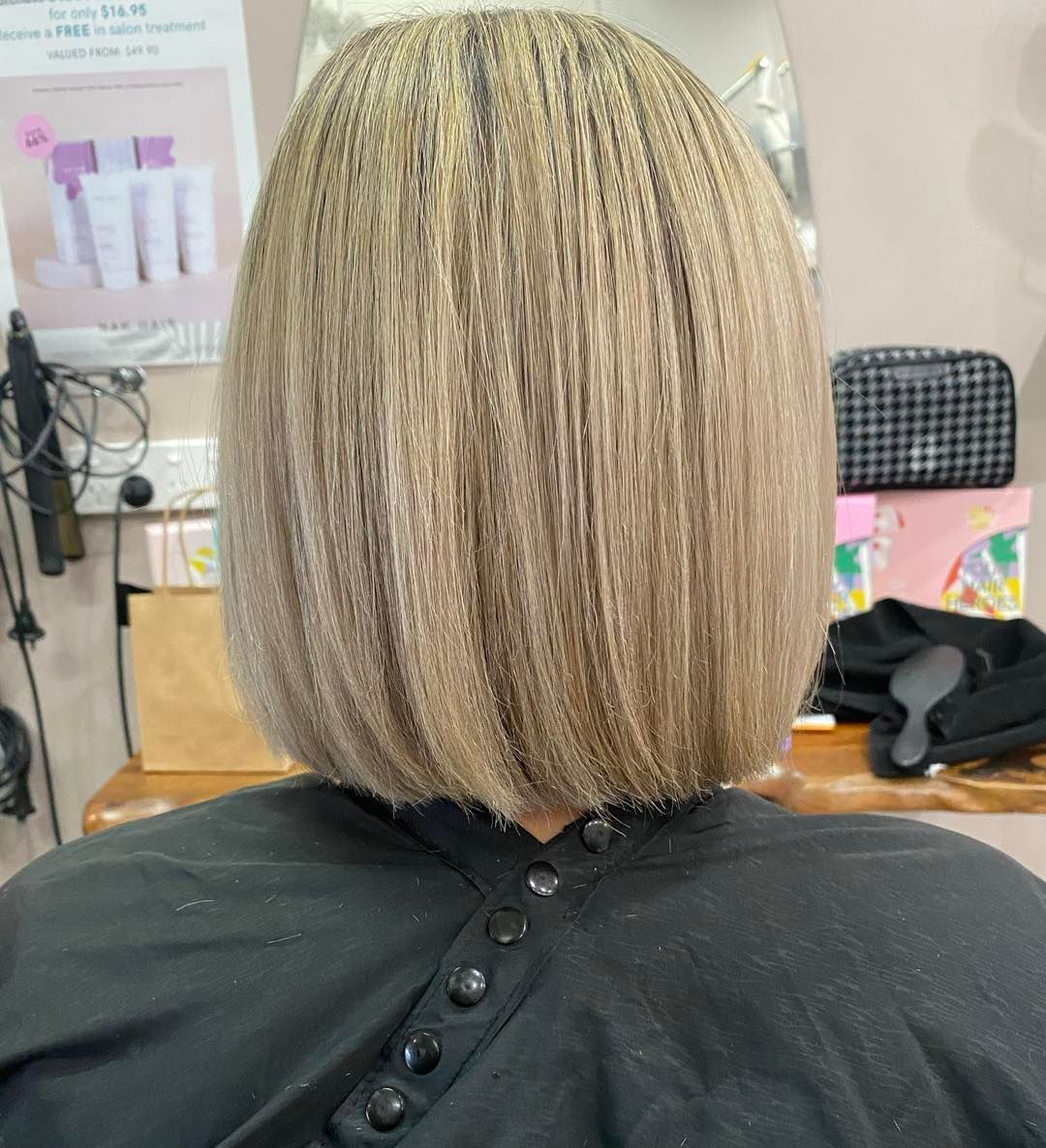 A Woman with Blonde Hair Is Getting Her Hair Cut in A Salon — Ammo Hair and Beauty In Maclean, NSW