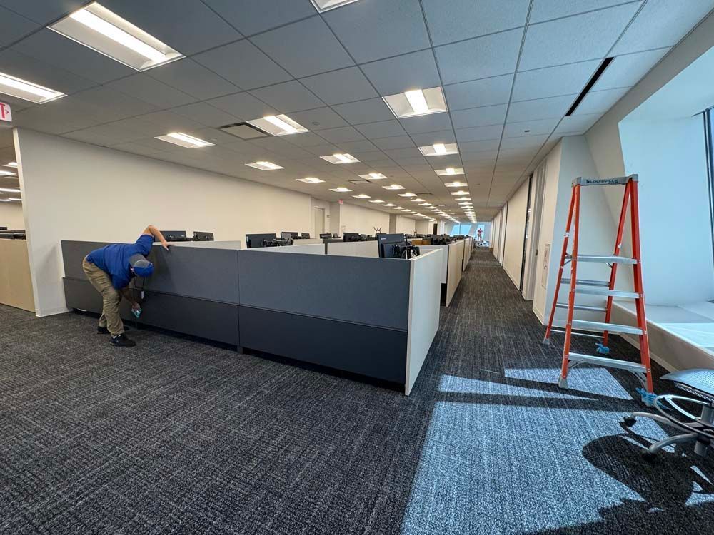 A man is cleaning cubicles in an office building.