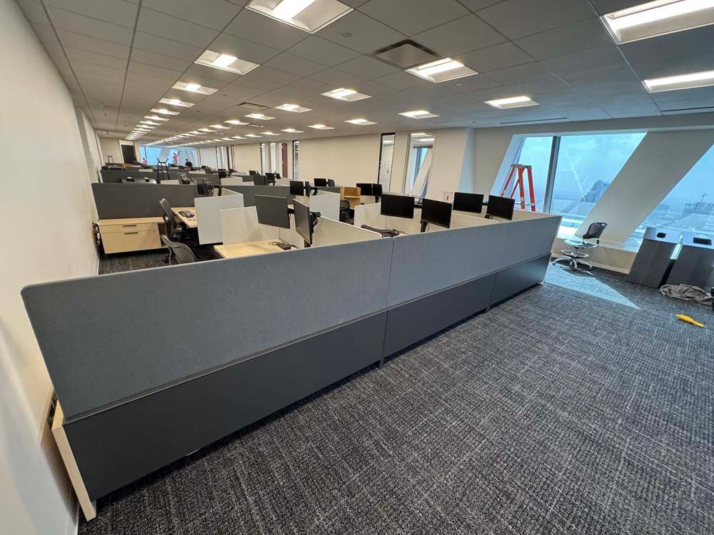 A large empty office with a lot of desks and computers.