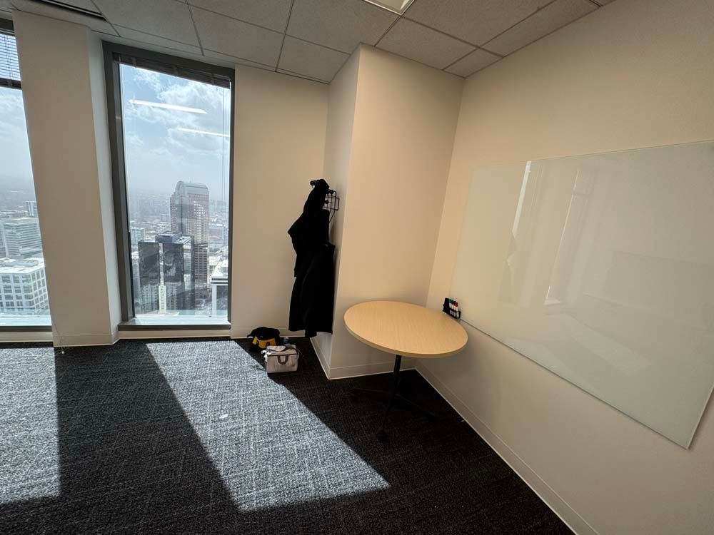 A room with a table and a white board on the wall