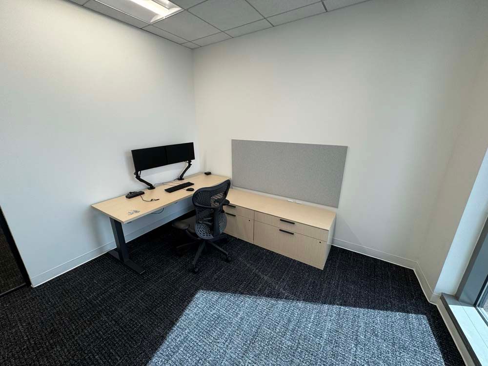 A small office with a desk and chair and a computer on it.