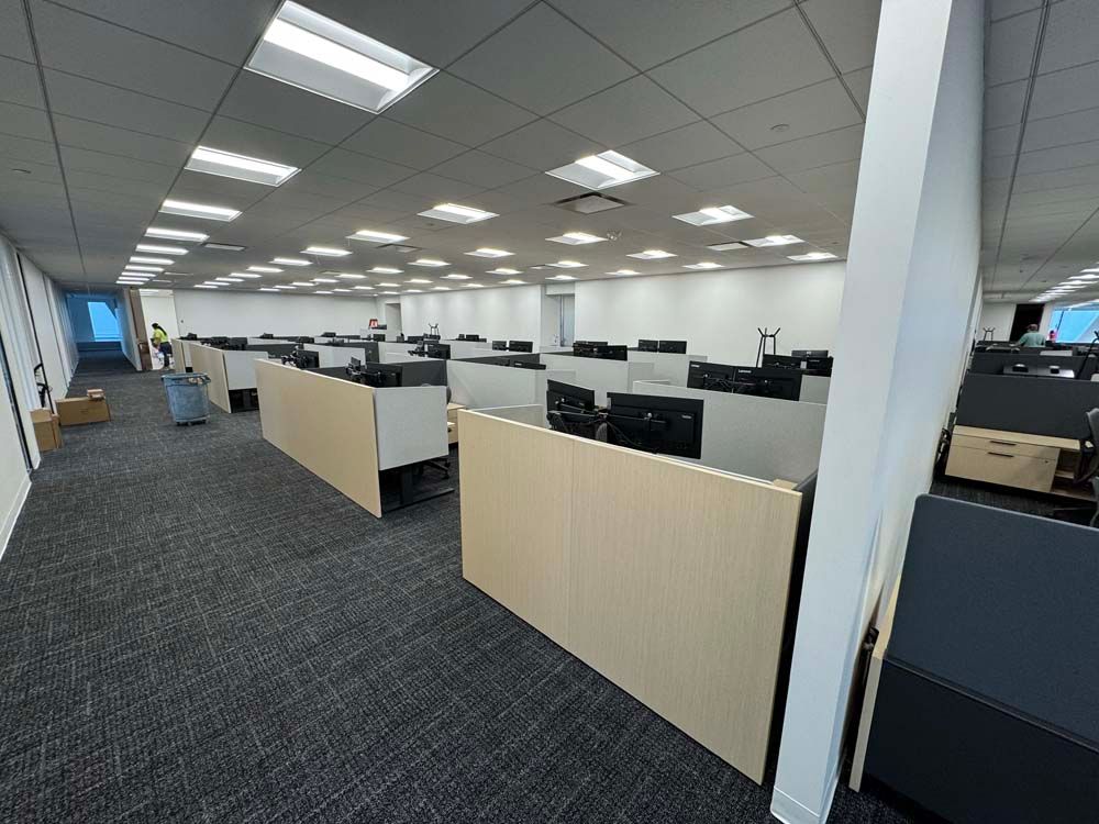 A large office with a lot of cubicles and computers.