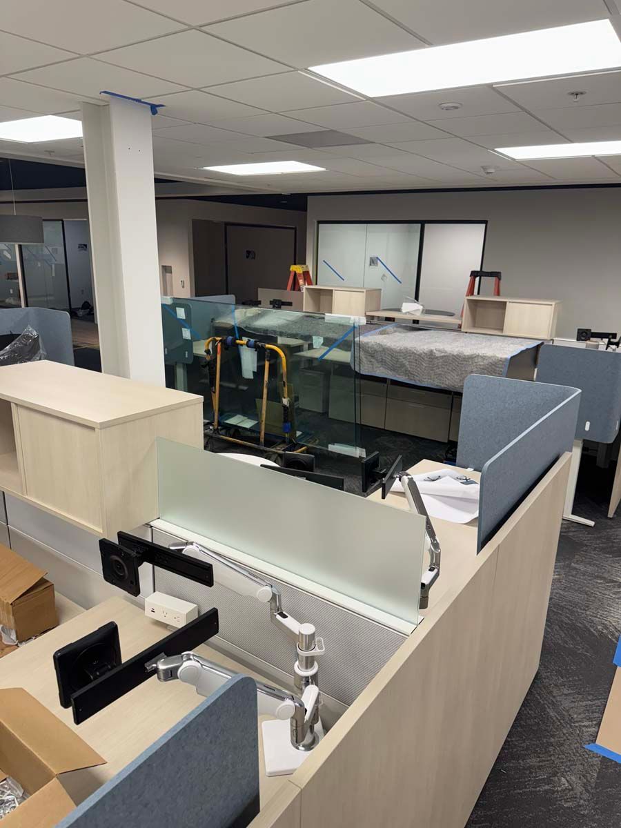 A room with a lot of cubicles and boxes on the floor