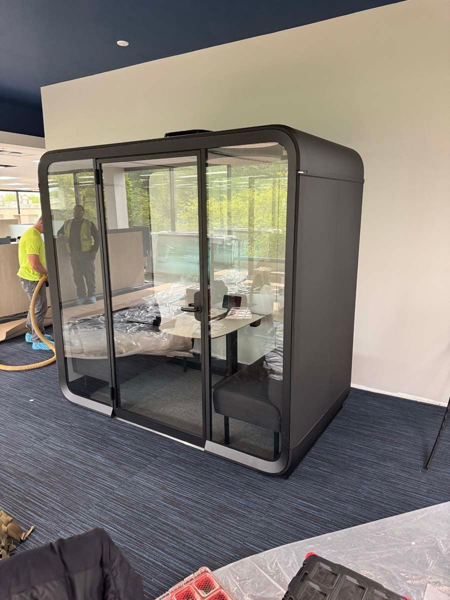 A room with a table and chairs in it is being built in an office.